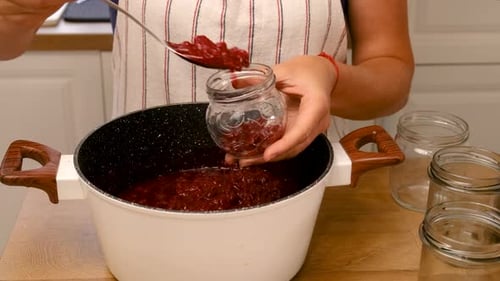 Mulher faz geleia na cozinha com foco seletivo