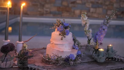rustic wedding cake with wild boho flowers by the pool, evening wedding reception