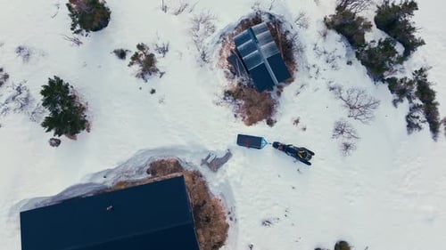 Overhead View Of Cabin And Snowmobile in Snowy Mountain At Winter. - aerial shot