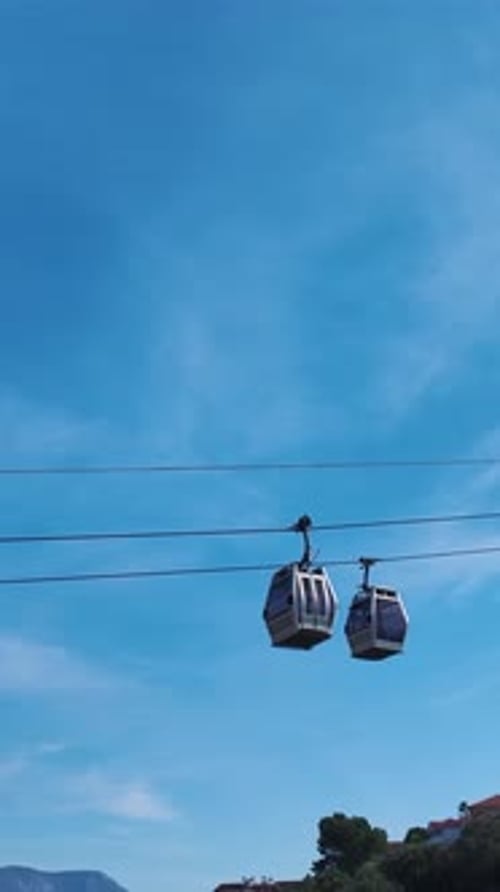 Vertical Video of a Scenic Funicular Moving Against a Bright Blue Sky Offering a Stunning Aerial