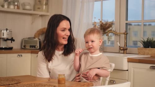 Baby Eats Food on Adult's Lap at Home