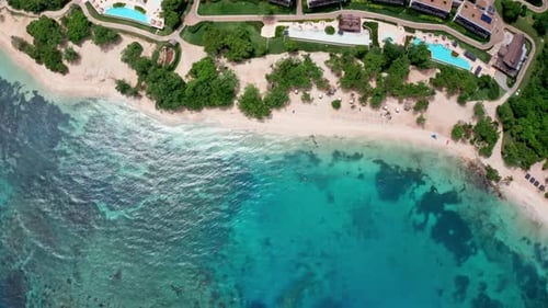Aerial drone view of holidays beach resort. View of the empty beach and the vibrant turquoise ocean.