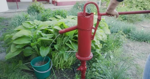 Person Using A Hand Water Pump - Close Up