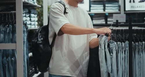 Men's Fashion Store Caucasian Man Looking for Clothes Person Choosing Clothes Selection Men's