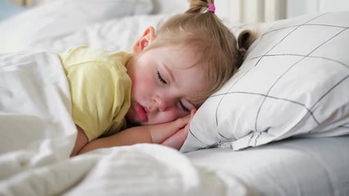 Child Sleeping Peacefully in Bed at Home