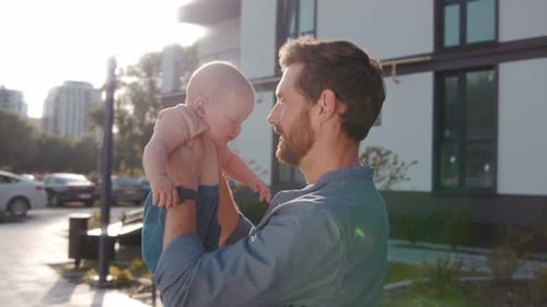 Loving Father Holding his Baby in the Sunshine
