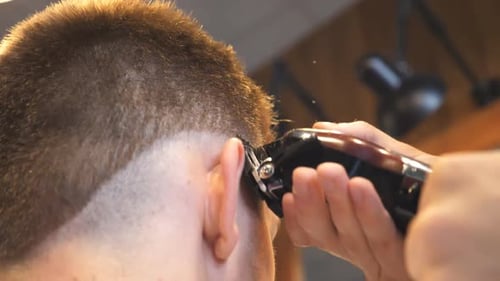 Barber Cuts Adult's Hair With Clippers
