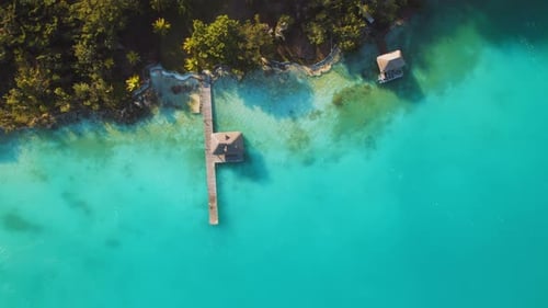 Embarcadère avec cabane au toit de chaume au-dessus des eaux turquoises du lagon à Bacalar, au Mexique