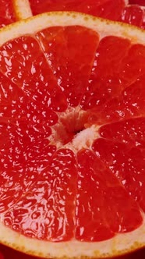 Grapefruitscheiben, rotierende Nahaufnahme, Fruchthintergrund, niemand, vertikal