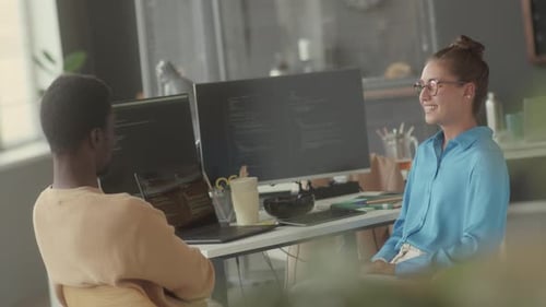 Two IT Specialists Sitting in Office and Discussing Work