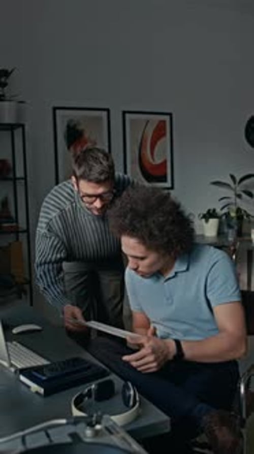 Man Asking his Colleague for Help with Documents in Modern Open Space Office