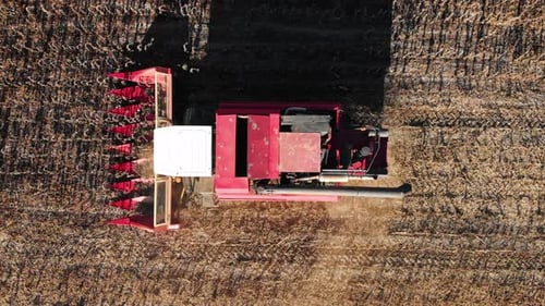 Aerial Shot of a Moving Combine Harvester Collecting Sunflower Seeds in Autumn Agriculture Food