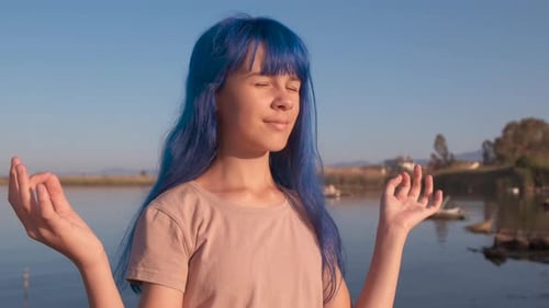 Teen Girl Meditating Peacefully By the Water