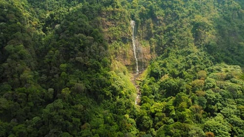 Aerial view of a tall Costa Rica waterfall surrounded by dense green jungle