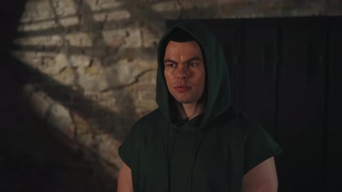 Sweaty man in hoodie standing against brick wall