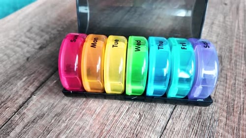 Boîte colorée en plastique pour consommer des pilules tous les jours. Vue de droite à gauche.