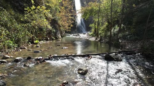 Waterfall Flowing into Rocky Stream in Nature Setting