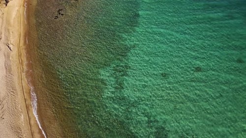 Birds Eye View of a Sandy Beach and Vibrant Turquoise Water