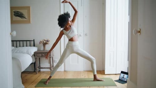Woman in sportswear doing yoga in bedroom