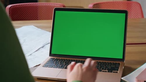 Typing on Laptop with Green Screen Over Shoulder