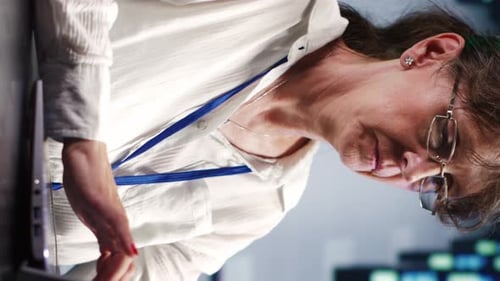 Woman Working on Laptop in Data Center