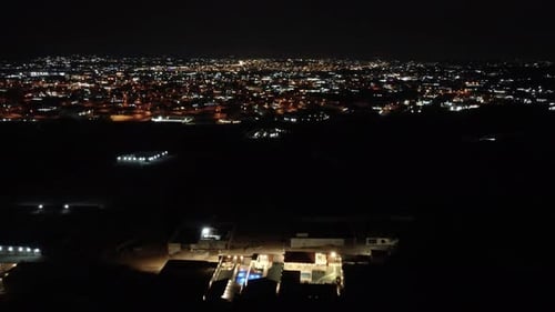 Aerial flying forward over residential neighborhood in Jeddah at night, Saudi Arabia