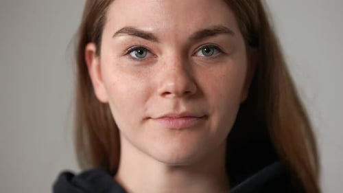 Closeup Front View Face of Confident Charming Young Woman Looking at Camera Smiling