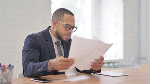 Enthusiastic Man Celebrates Reading Good News in Office