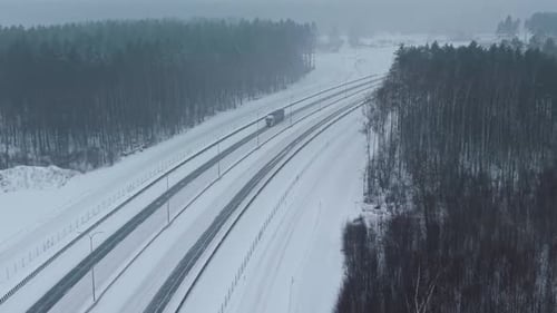Paisagem congelada com estrada solitária A estrada coberta de neve se estende por uma paisagem florestal tranquila