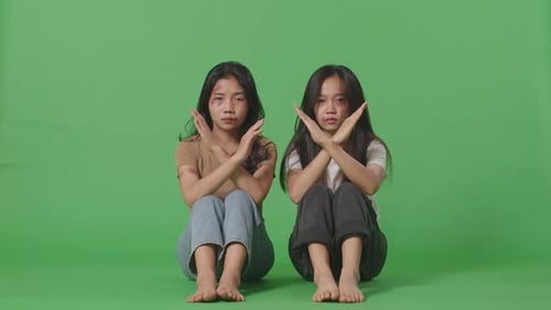Women Victims Of Violence Showing Hands Cross To Stop Violence While Sitting On The Green Screen