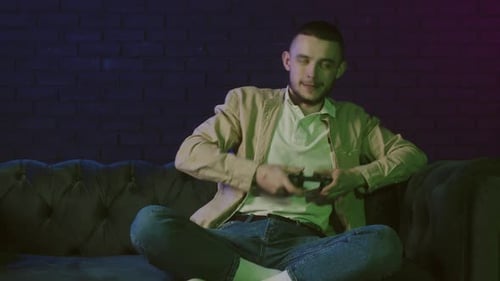 Young Man Winning at Video Game on Couch