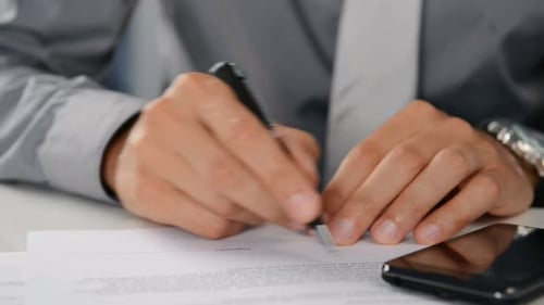 Geschäftsmann unterschreibt im Büro einen Geschäftsvertrag mit einem Füllfederhalter