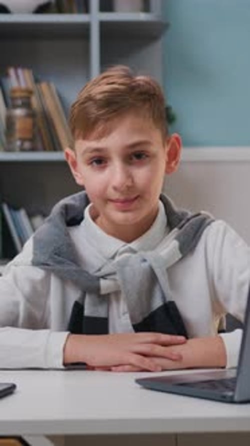 Porträt eines süßen Jungen, der in die Kamera schaut, lächelt und lustige Gesichter macht, ein glückliches Kind, das er dem zuschaut