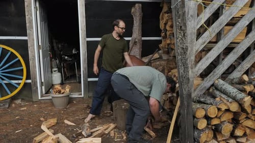 Two Men Splitting and Stacking Firewood Together