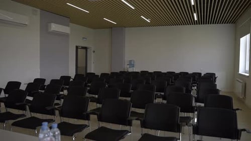 Empty Conference Room with Rows of Black Chairs