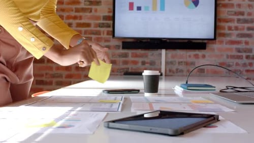 Midsection of african american casual businesswoman looking at documents in office, slow motion