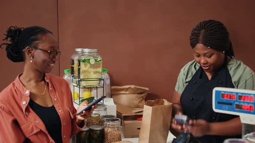 Woman Pays at Register in Indoor Market
