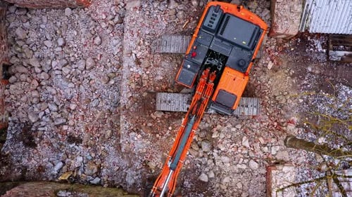 Vue aérienne de haut en bas d'une excavatrice inutilisée dans les ruines d'un bâtiment en pierre en hiver