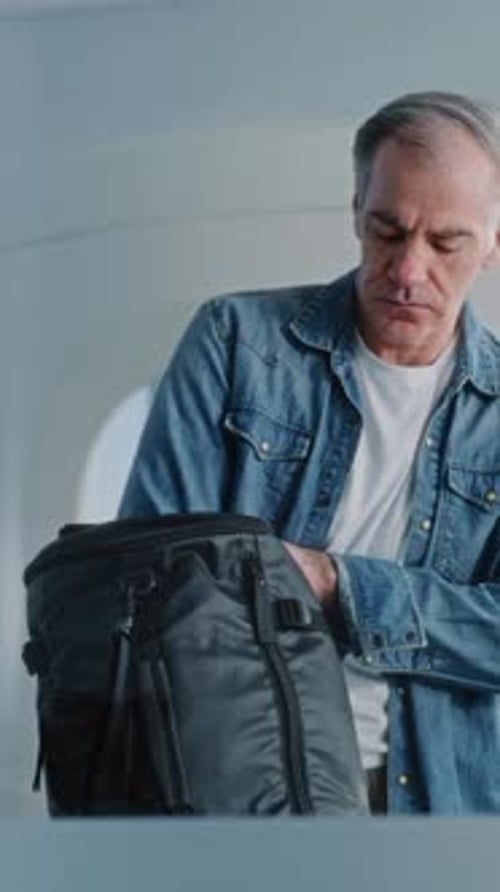 Gray Haired Man and Brunette Woman Pack Luggage