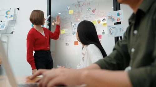 Business Team Brainstorming Ideas on Whiteboard in Office