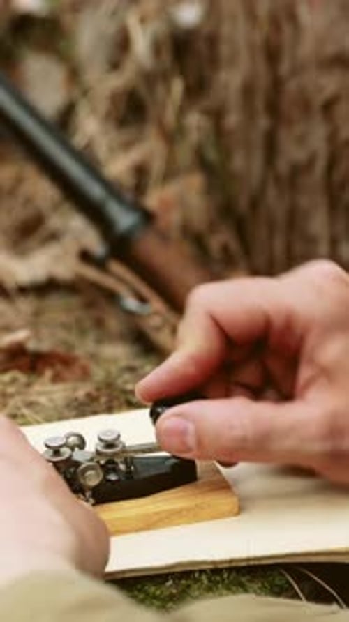 Hands Operating Telegraph with Rifle in Background