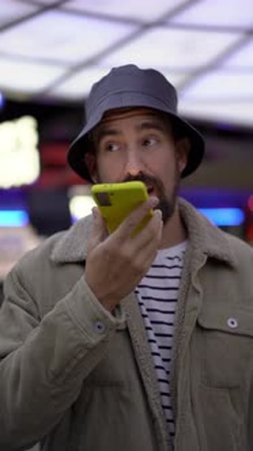 Caucasian Man Sending Voicemail with Smartphone While Standing at Shopping Mall