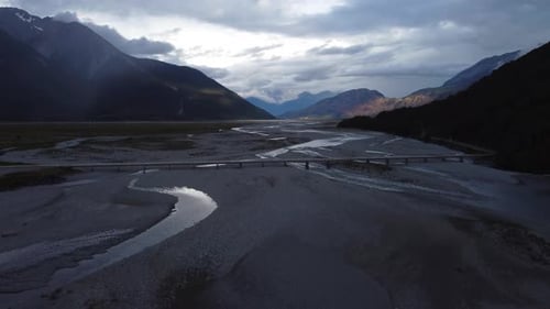 Drone around New Zealand Alps as vehicles drive across bridge
