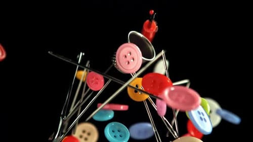 Colorful Sewing Buttons and Needles Floating on Black