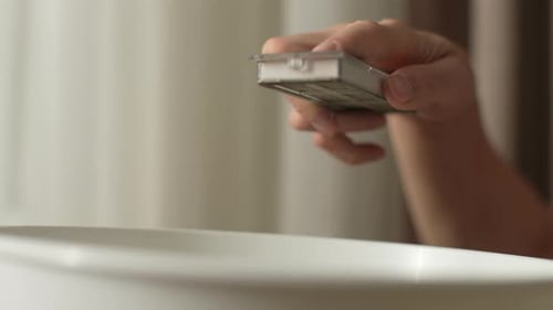 Hand Sprinkling White Powder into White Bowl
