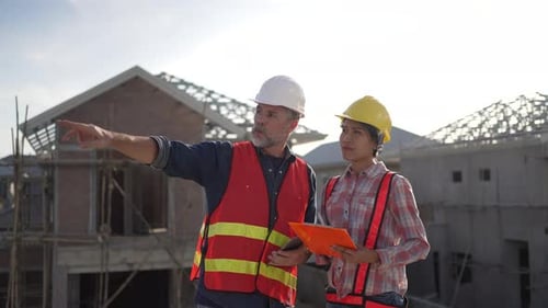 Trabalhadores de colarinho azul estão construindo uma casa.