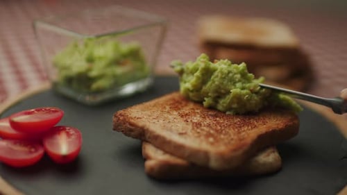Spreading avocado on toast for breakfast