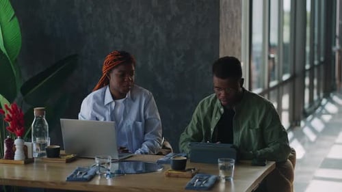 At a Meeting in a Cafe Black Workers Actively Discuss Business Issues Related to Startups and