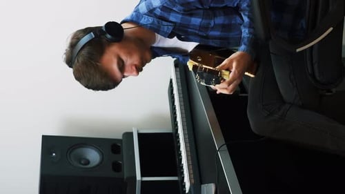 Guitarist playing on electric guitar at home recording studio. Vertical video