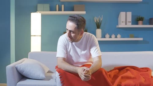 Man Experiencing Pain or Discomfort on Couch
